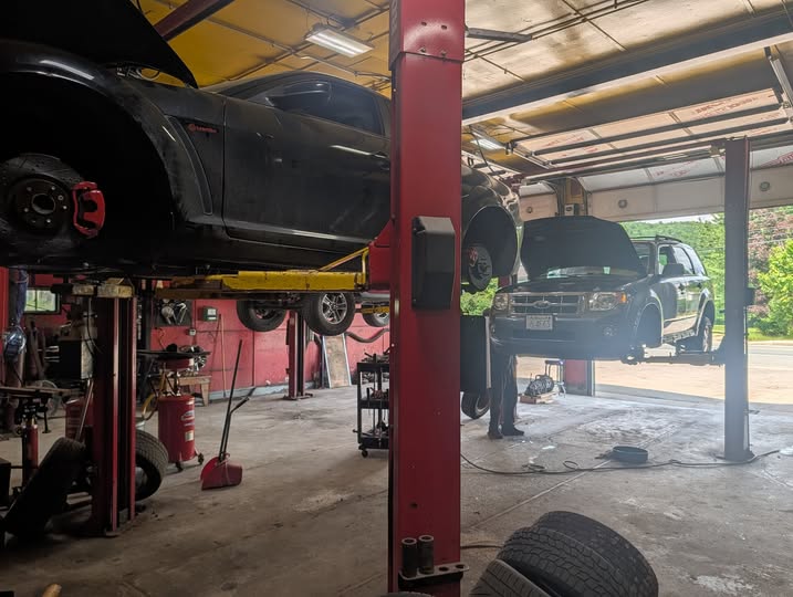 Inside the R&R Auto Repair garage with two vehicles up on lifts